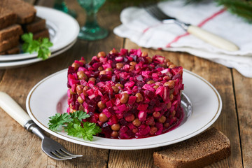 Vegetable salad vinaigrette with beetroot, potatoes, pickles and green peas on a plate