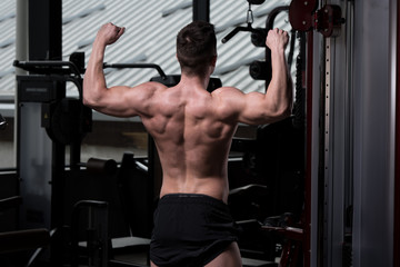 Fototapeta na wymiar Bodybuilder Performing Biceps Pose