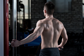 Fototapeta na wymiar Young Man Exercising Shoulder In The Gym