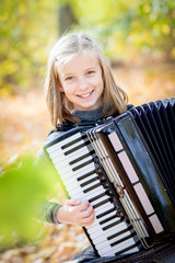 portrait of a happy girl holding an accordion