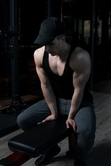 Fototapeta na wymiar Attractive Young Man Resting In Gym Afther Exercise