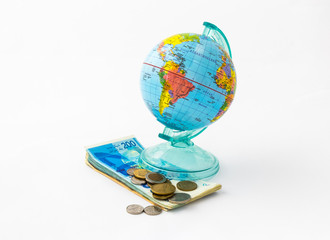 A  money box made in the form of a globe, the planet Earth with a money slot at the top stands on a...