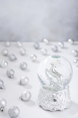 Defocused christmas background with silver christmas water globe and balls