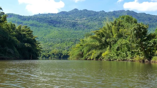 Kwai Yai river with view of mountain and blue sky in Amphoe Srisawat,Kanchanaburi Thailand,handheld on kayak boat.