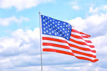 American flag outdoors on cloudy day. Space for text