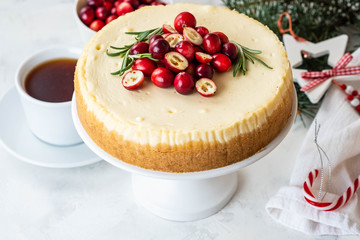 Cheescake with fresh cranberry and rosemary. Christmas cake with decoration on white background.
