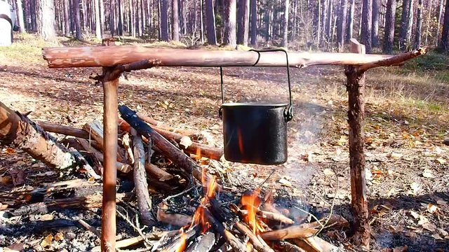 A pot to boil on the fire. Extreme tourism in the wild forest. 