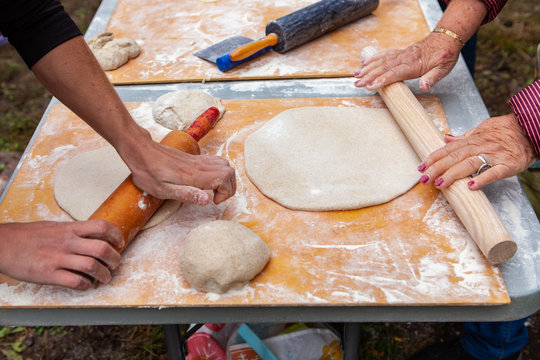 People kneading their pizza doughs as part of an outdoor bread making workshop - wide angle - Pictures taken during a bread and pizza making workshop