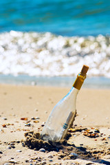 Bottle with a message, lying on the seashore