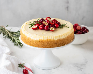 Classic New York Cheesecake with cranberry, rosemary and tea on White Concrete Background, copy spase. Tea and Cheesecake