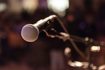 Vocal microphone pictured on a stage with a blurry background with bokeh - Closeup picture taken at a storytelling and folk music festival in Quebec, Canada