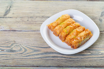 Traditional arabic dessert baklava with cashew, walnuts and cardamom with an eucalyptus branch on a wooden table