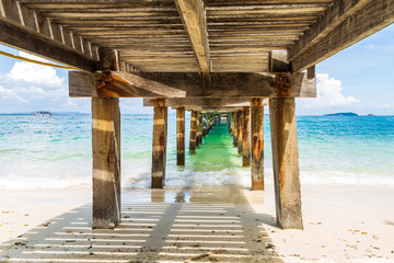 Fototapety  Piękny obraz rozpryskująca się fala morska pod starym mostem betonowym i drewnianym.