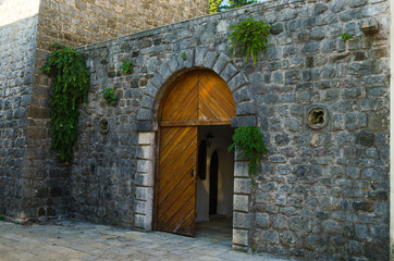 Wooden gate of the old town. Stone wall of the castle.