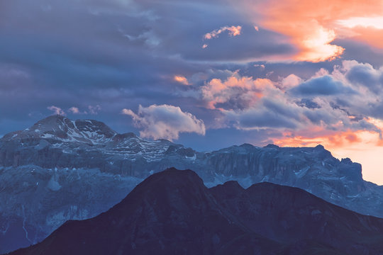 Beautiful mountain peaks covered by colored clouds at sunset, mountain landscape background © e_polischuk