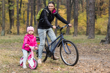 Naklejka premium Happy mother and daughter riding bicycles.