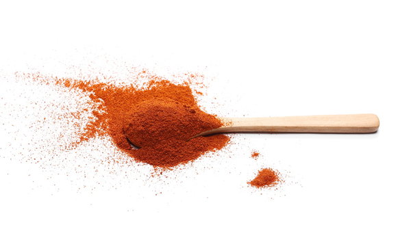 Pile of red pepper, paprika powder with wooden spoon isolated on white background