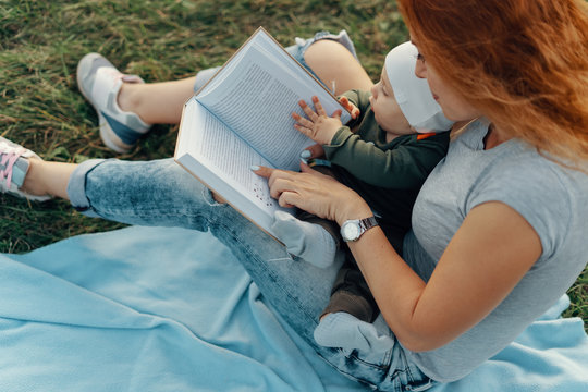 Beautiful Mom Is Reading A Book With Her Cute Baby Boy