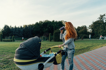 Young mother walking with her child in the morning while drinkin