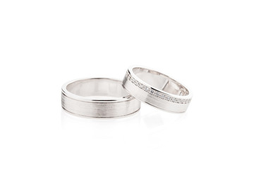 Pair of silver wedding rings with diamonds isolated on white background