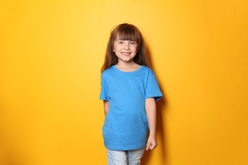 Little girl in t-shirt on color background