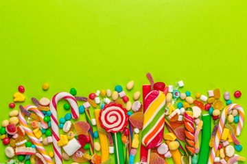 Colorful candies on green background