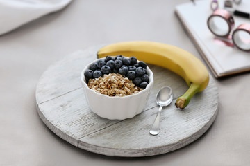 Wooden board with delicious breakfast on bed