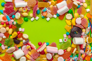 Colorful candies on green background