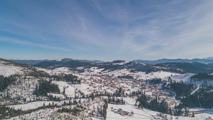 Aerial view of the mountains. Carpathians. Bukovel. Village. Winter. Snow. Forest. Trees