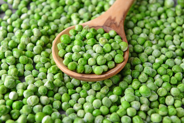Frozen green peas with spoon, closeup