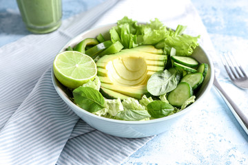 Plate with healthy vegetable salad on color table