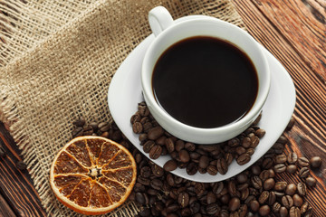Coffee cup and coffee beans on wooden background