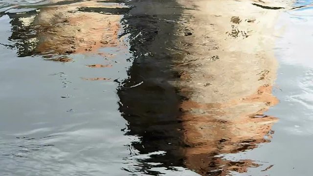 Reflection of the ancient fortress in the water. Background surface wave motion. 