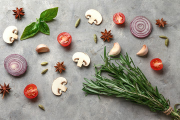 Fresh aromatic herbs with vegetables and spices on grey background