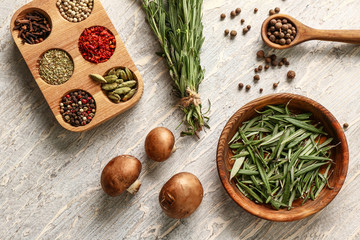 Fresh aromatic rosemary with mushrooms and different spices on light background