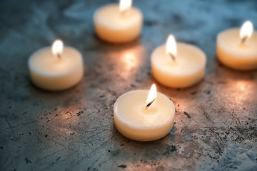 Fototapeta na wymiar Beautiful burning candles on grey table