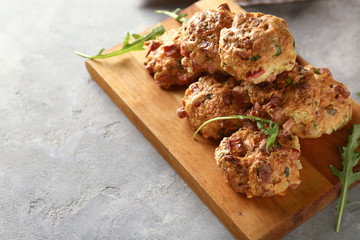 Wooden board with tasty sausage balls on table