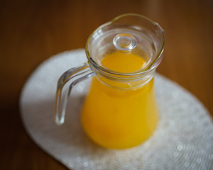 Glass carafe with compote from sea-buckthorn in the kitchen. Shallow depth of field.