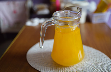 Glass carafe with compote from sea-buckthorn in the kitchen. Shallow depth of field.