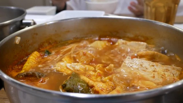Motion of people eating hot pot with boiling soup inside Chinese restaurant with 4k resolution