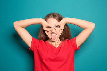 Portrait of funny young woman on color background