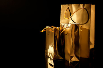 Golden shopping bags on black background