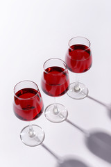 Glasses with sweet tasty wine on white background