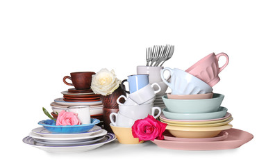 Set of clean tableware with flowers on white background