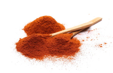 Pile of red pepper, paprika powder with wooden spoon isolated on white background