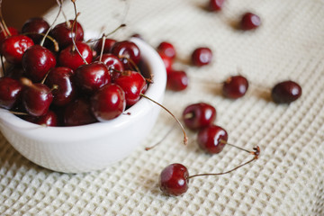 Obraz na płótnie Canvas Fresh cherry on plate on towel background. fresh ripe cherries. sweet cherries.