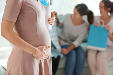 Obraz premium Beautiful pregnant woman with gift box at baby shower party