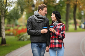 Obraz premium Loving young couple with coffee on romantic date in autumn park