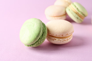 Fresh tasty macaroons on color background