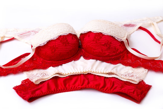 Collection of red and beige push up bras and silk panties isolated on white background